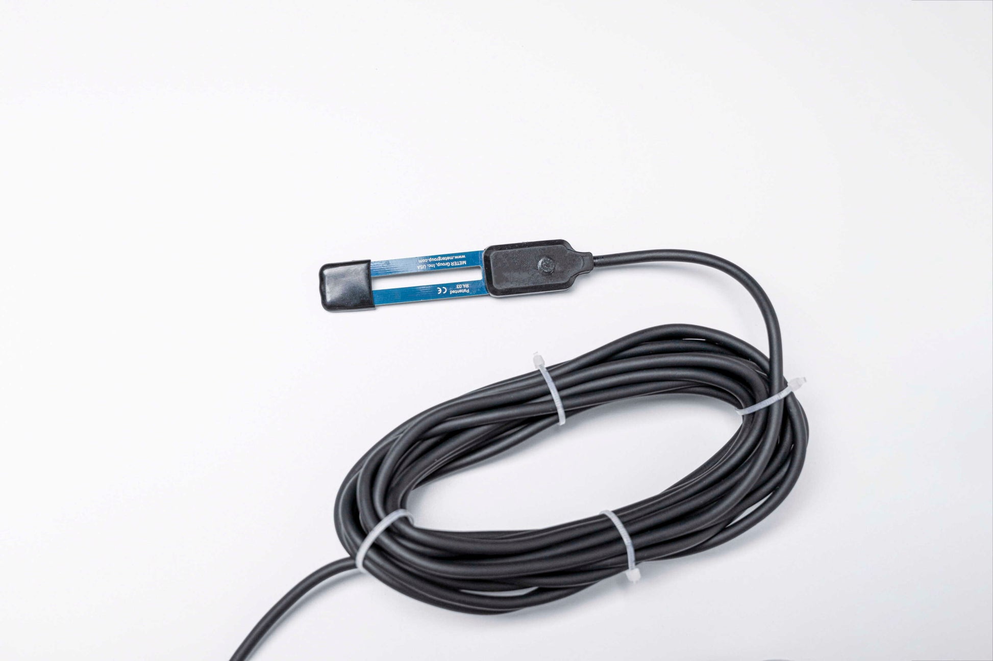 Close-up of an agricultural IoT sensor connected to a Helium Hotspot in a rural African farm setting, showcasing decentralized wireless technology for smart farming.